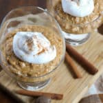Pumpkin rice pudding in bowls. Topped with whipped cream and a sprinkle of cinnamon.