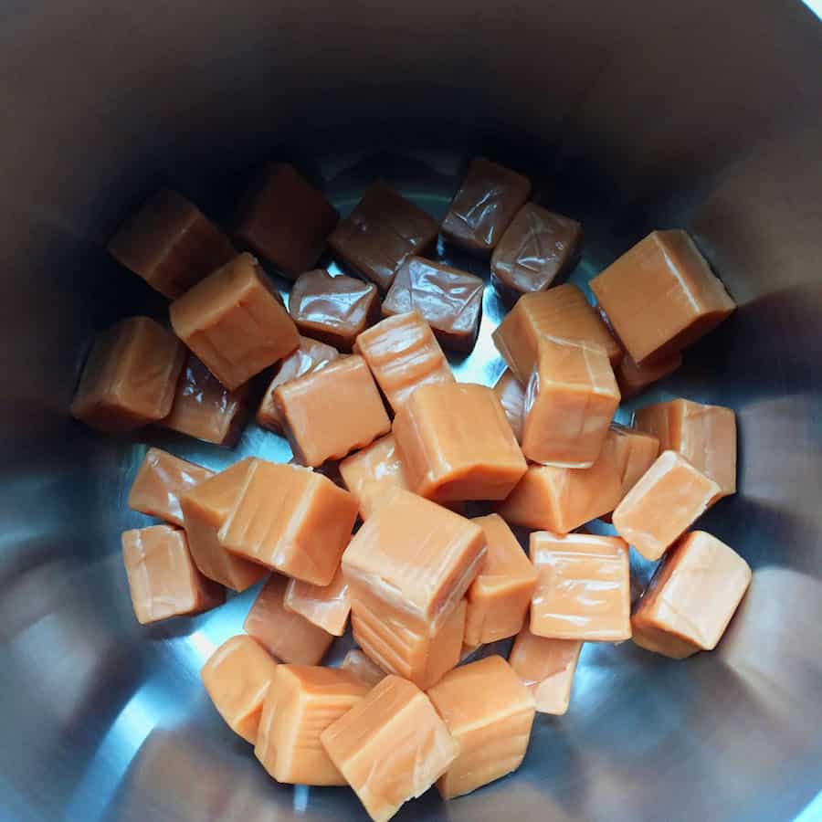 Unwrapped caramel candies in the bottom of a pot.