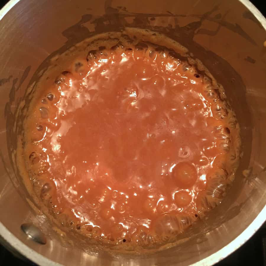 Cooked caramel sauce bubbles at the edges of the pan.