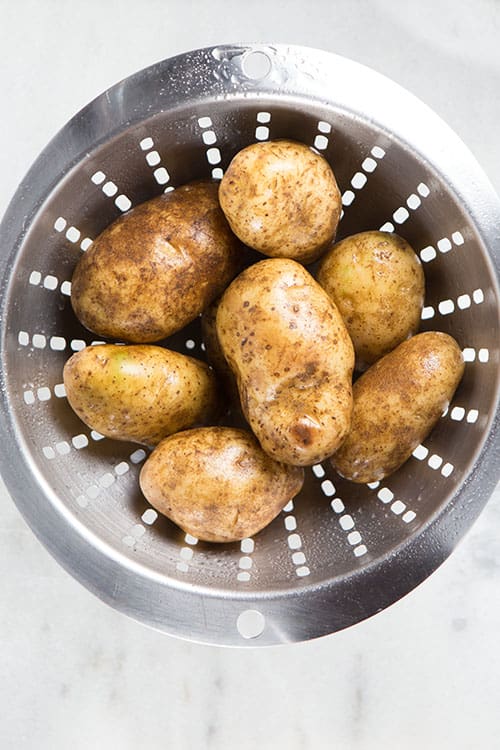 Strainer with washed potatoes.