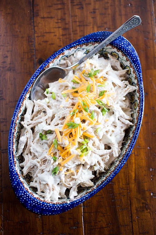 Pressure cooked shredded chicken with cream cheese in a blue serving dish.