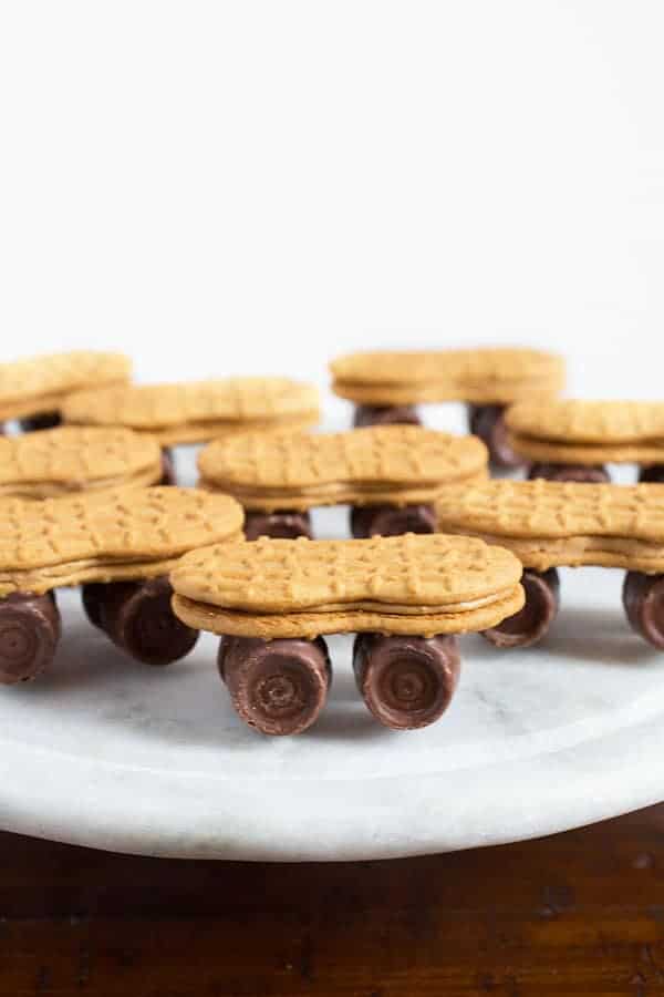 Nutter Butter cookie skateboards with rolo wheels on marble serving plate.