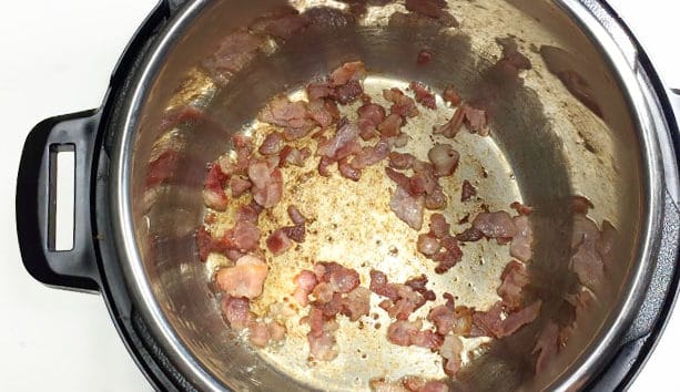 Cooked bacon in the bottom of a Pressure Cooker pot.
