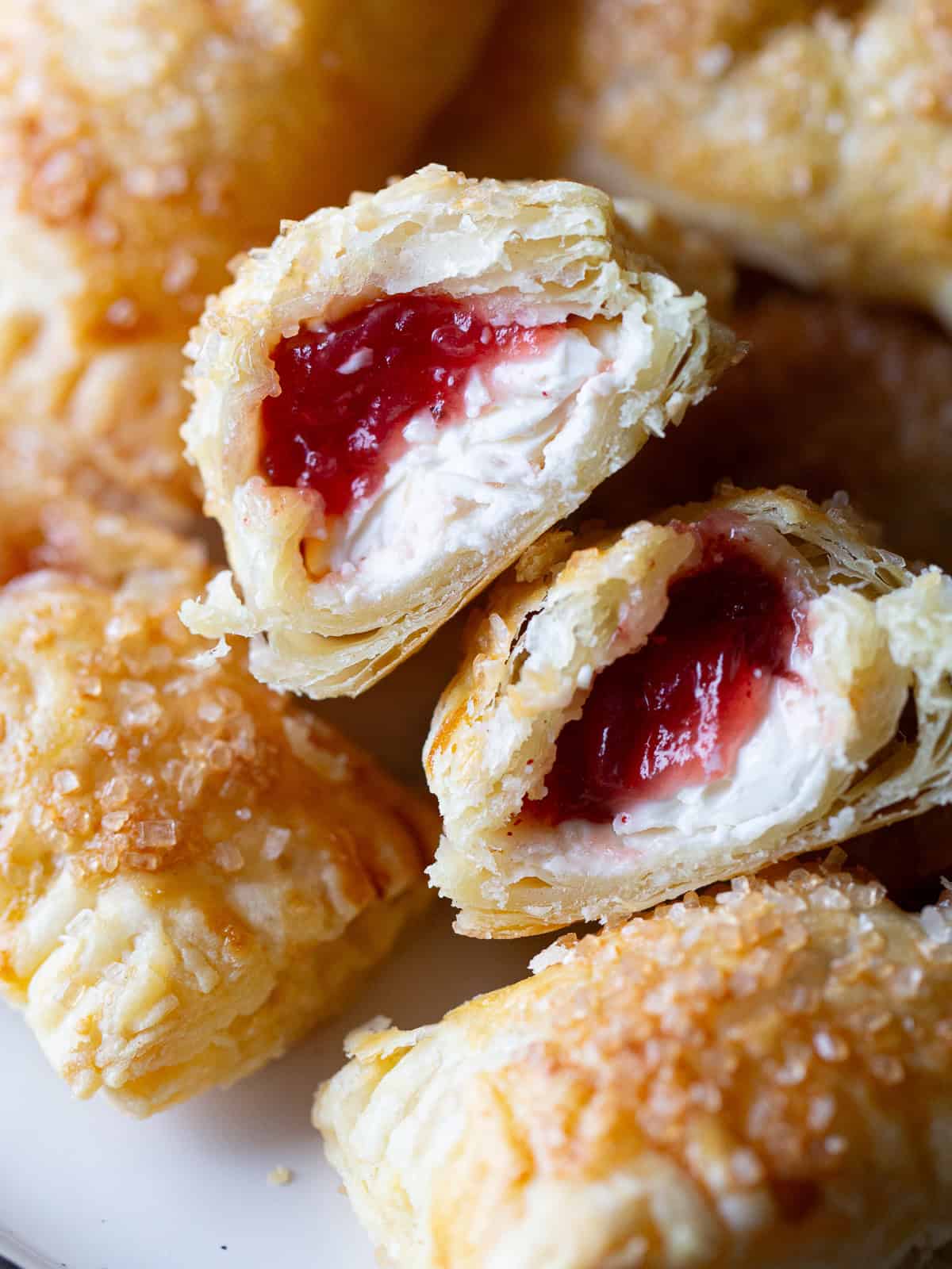 Cranberry cream cheese hand pie split in half to show the filling. 