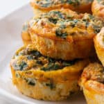 Baked Egg Cups with Spinach Stacked on a Plate.