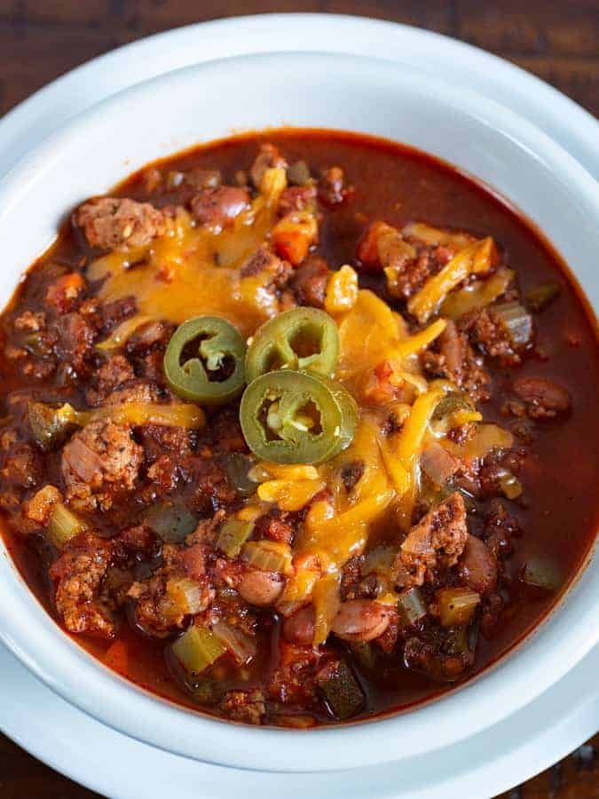 Bowl of Turkey Chili. Topped with shredded cheese and pickled jalapeños. 