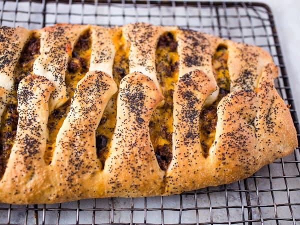 Ground beef and cheese stromboli on wire rack.