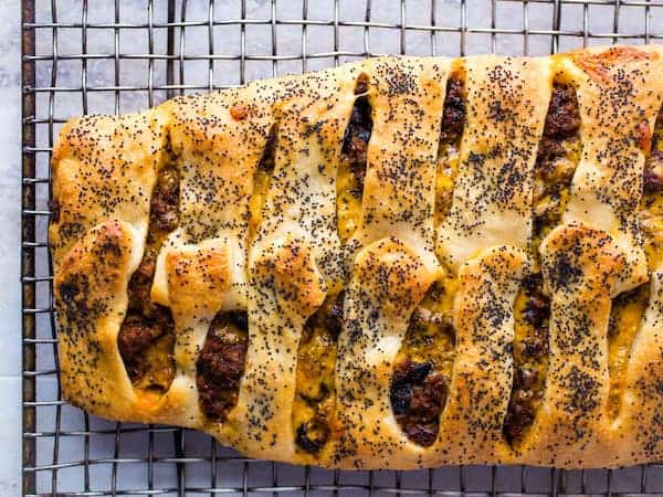 Ground beef and cheese Stromboli on wire rack.