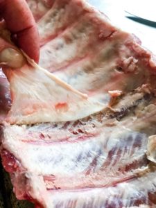 Removing the silverskin membrane from ribs.