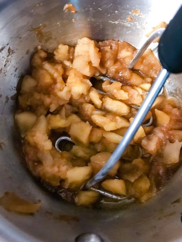Mashing apples in a small pan. 