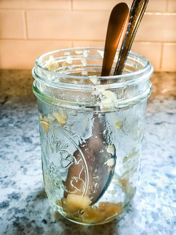 Empty half pint jar with two spoons.