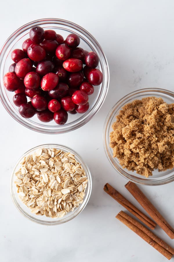 Bowl of Fresh Cranberries. Bowl of Oats. Bowl of Brown Sugar. Three cinnamon sticks. 