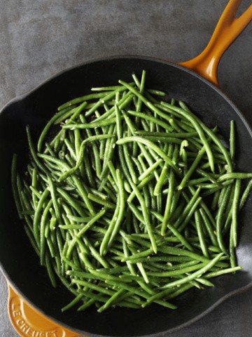 Cooked green beans in a skillet.