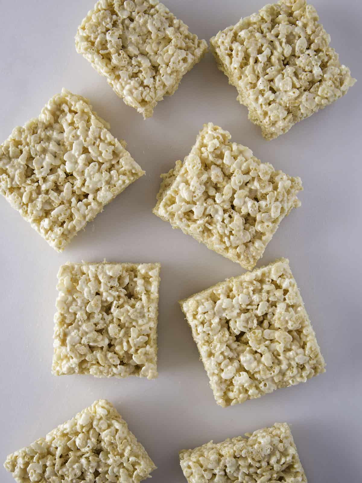 Cut rice krispie treats on a white board.