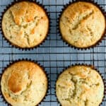 Four baked banana muffins on a cooling rack.