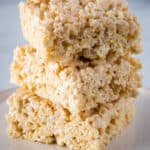 Three rice crispy treats stacked on a plate.