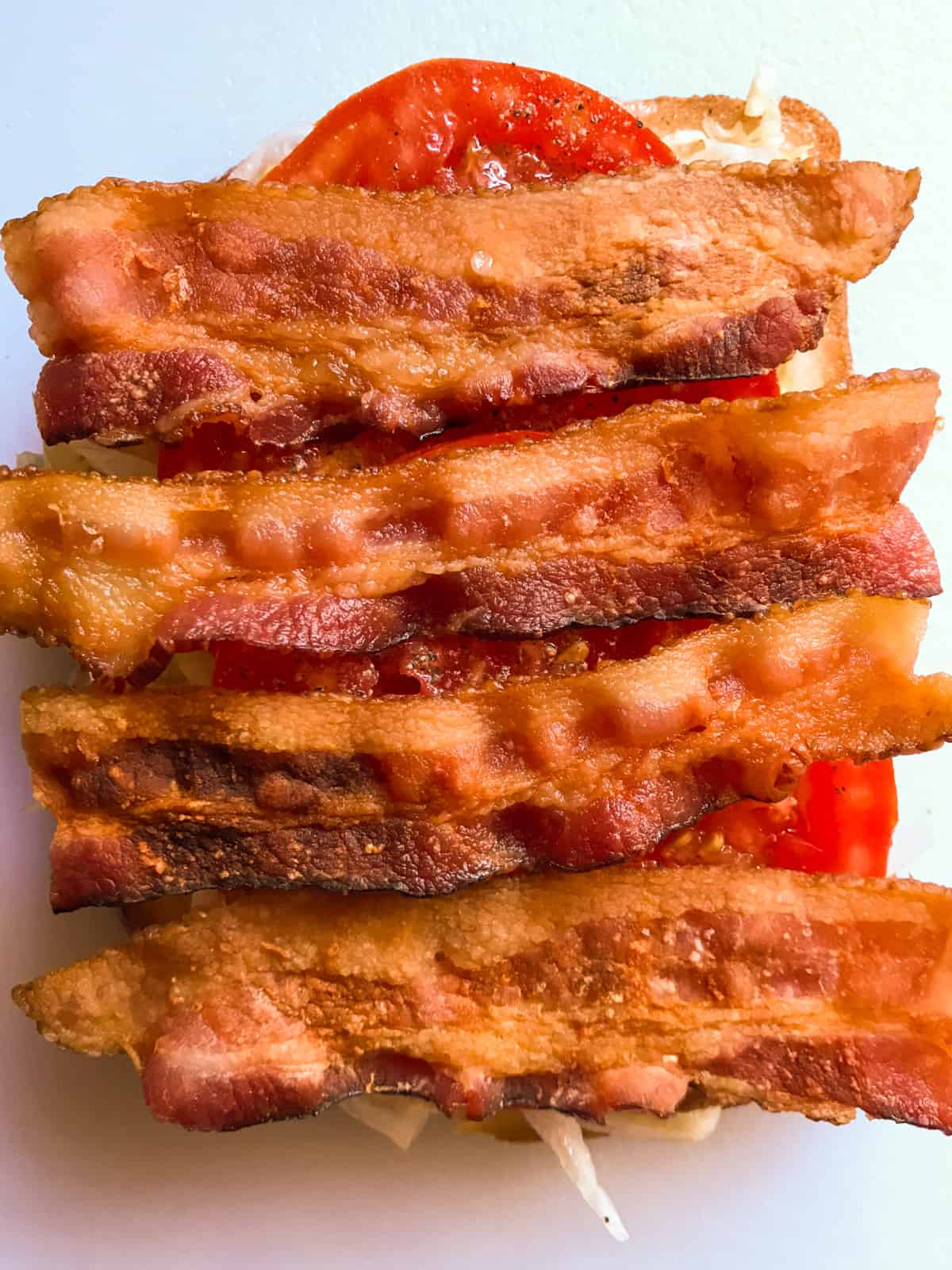 Four slices of bacon on BLT sandwich.