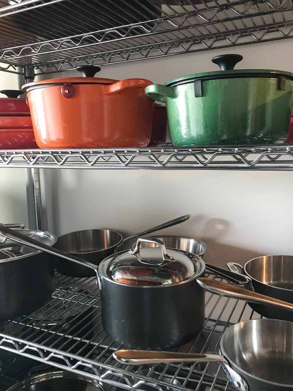 Two shelves full of pots and pans.