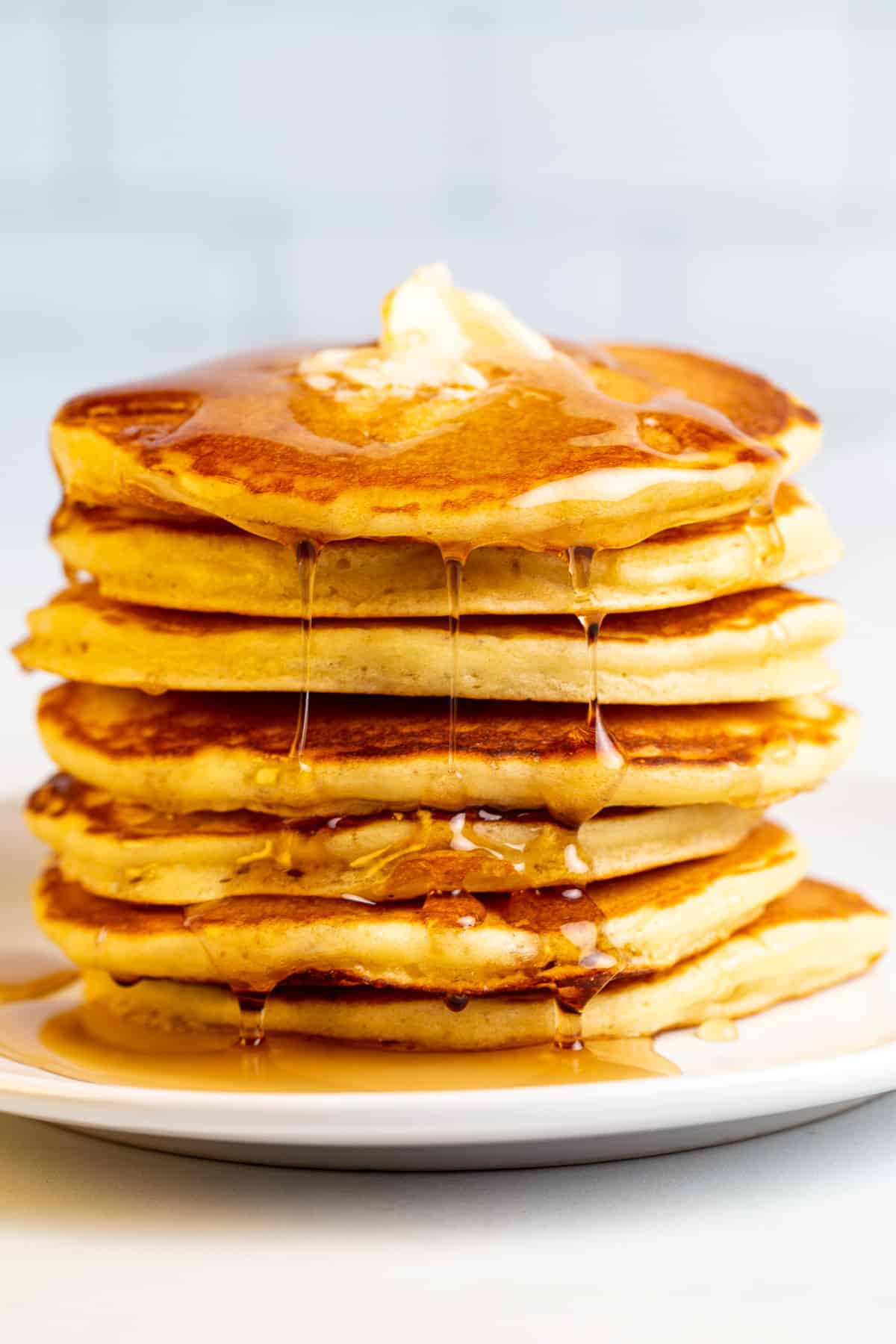 A Stack of Pancakes on a Plate with Syrup