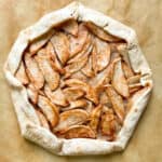 Baked apple galette on brown parchment paper.
