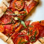 Tomato galette sliced on cutting board.