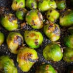 Frozen Brussels sprouts cooked with onions in a pan.