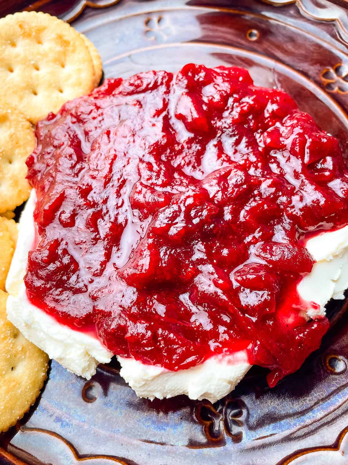 Cranberry cream cheese spread on a plate with crackers.