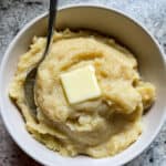 Mashed potato squash in a bowl with a pat of butter on top.