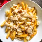 Turkey poutine in a white bowl.