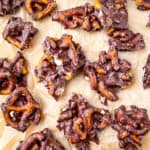 Chocolate pretzel bark broken into pieces on brown parchment.