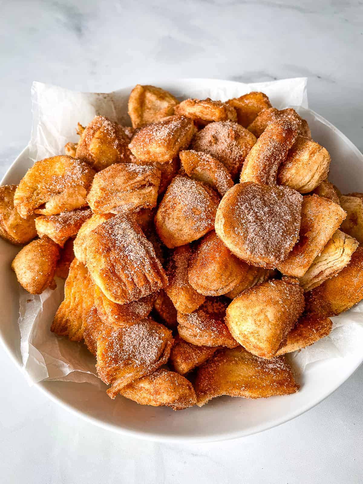 Cinnamon-sugar biscuit bites on a plate.