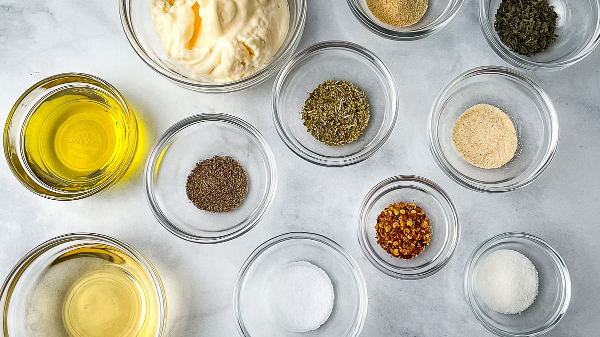 Ingredients for creamy Italian dressing in small bowls.