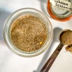 Homemade mushroom seasoning in jar. Teaspoon and lid sit off to the right side.