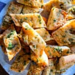 Roasted garlic bread slices on a plate.