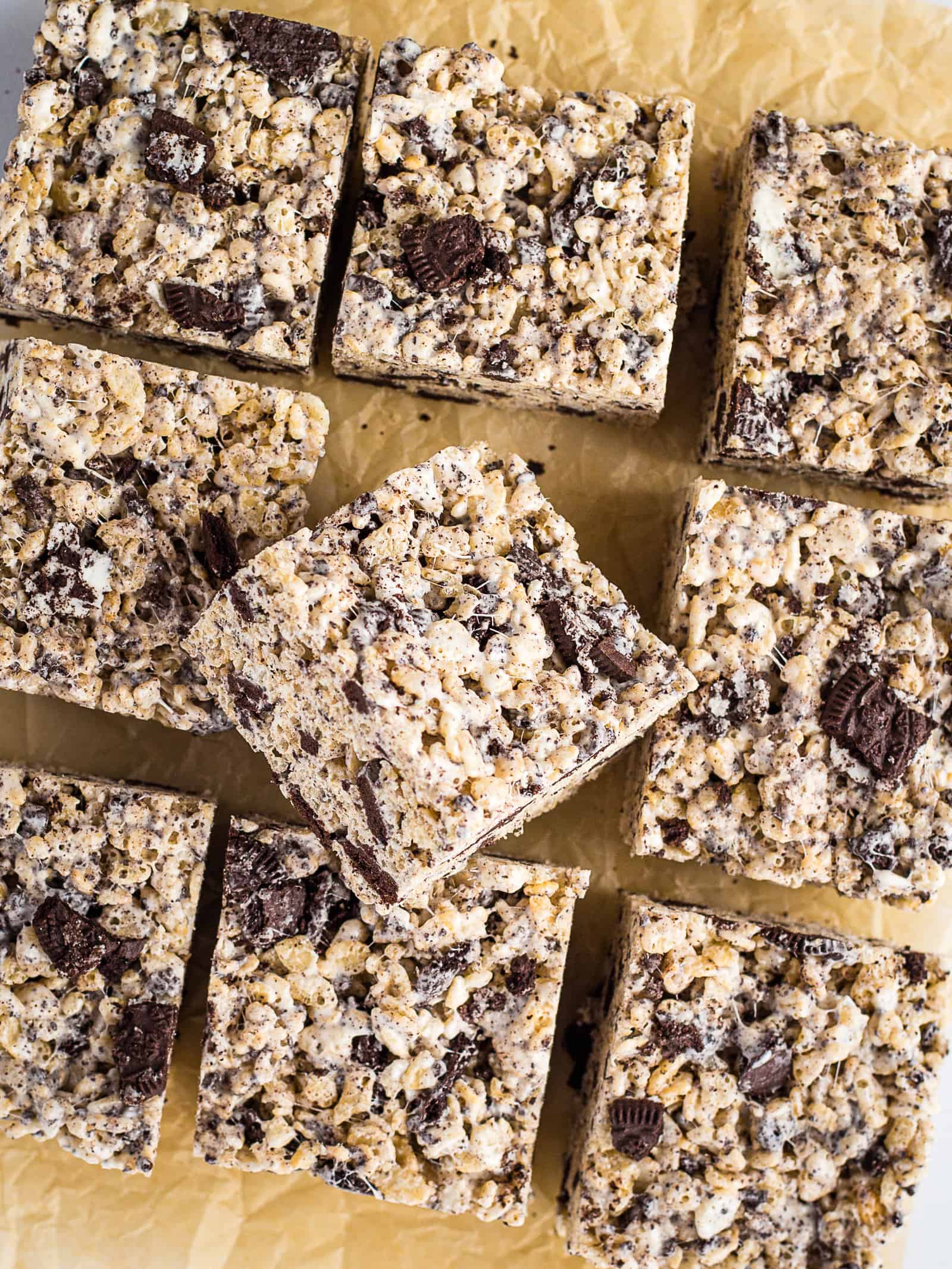 Cookies and cream rice krispy treats cut into squares on brown parchment paper.