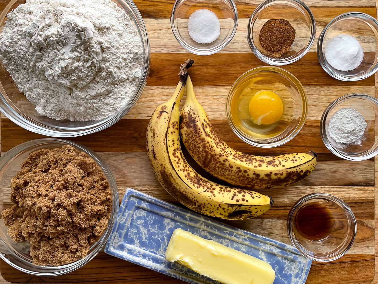 Ingredients for soft banana cookies sitting on a wood cutting board.