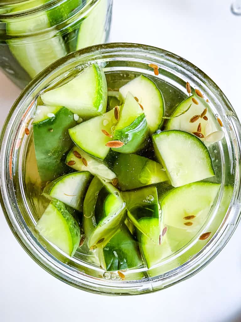 Refrigerator dill pickles in jar with brine.