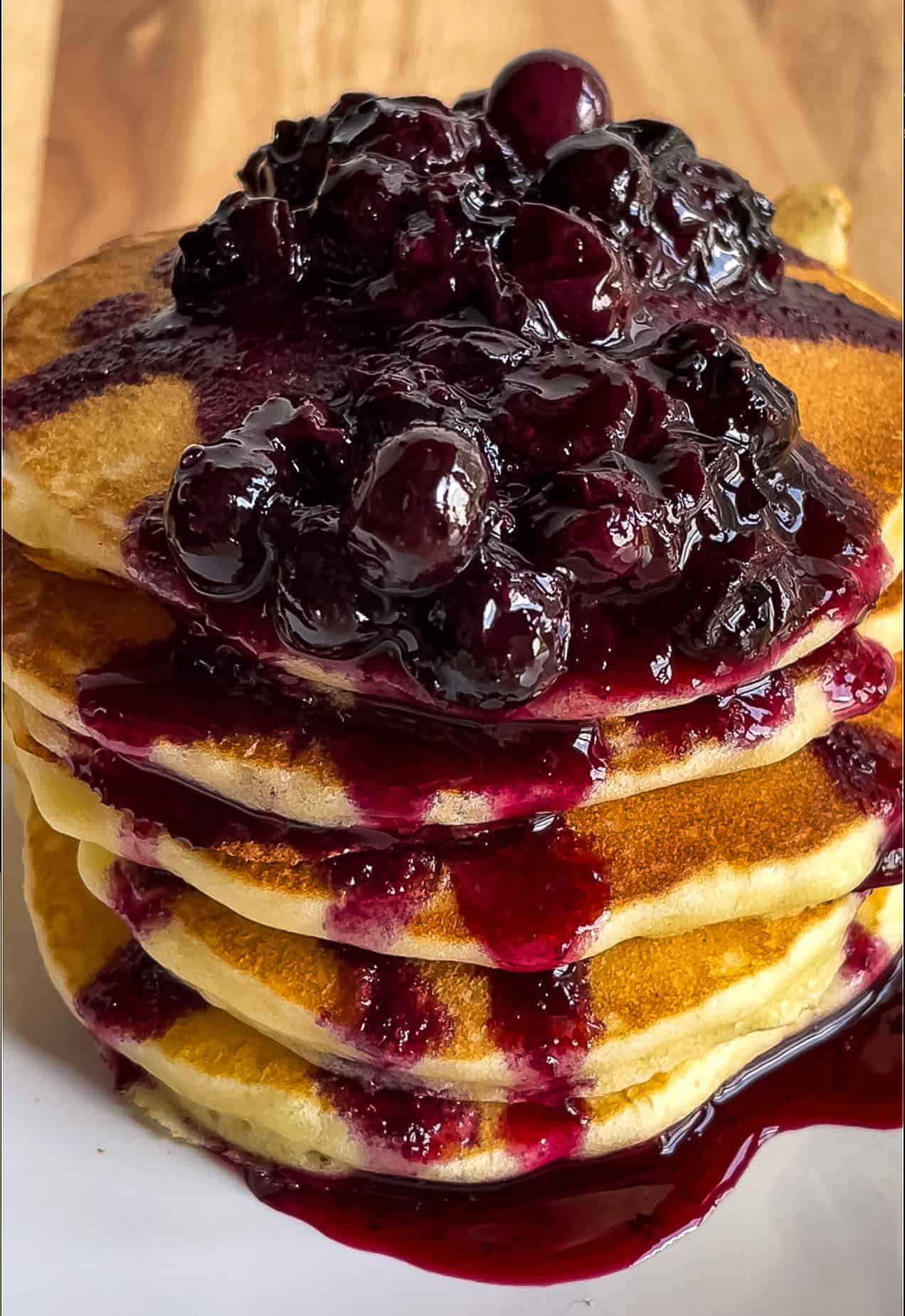 Blueberry maple syrup on a stack of pancakes.