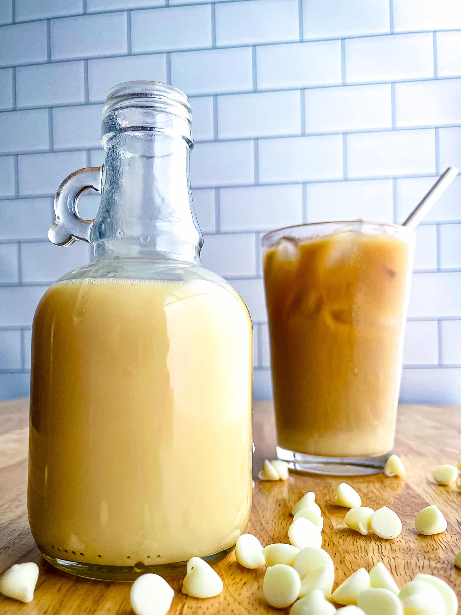 Bottle of white chocolate sauce. A glass of iced coffee sits in the background.