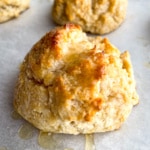 Honey butter biscuit with glaze on a sheet pan.