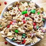 Cinnamon spiced Chex mix in a bowl. There are red and green M&Ms candy throughout the mix.