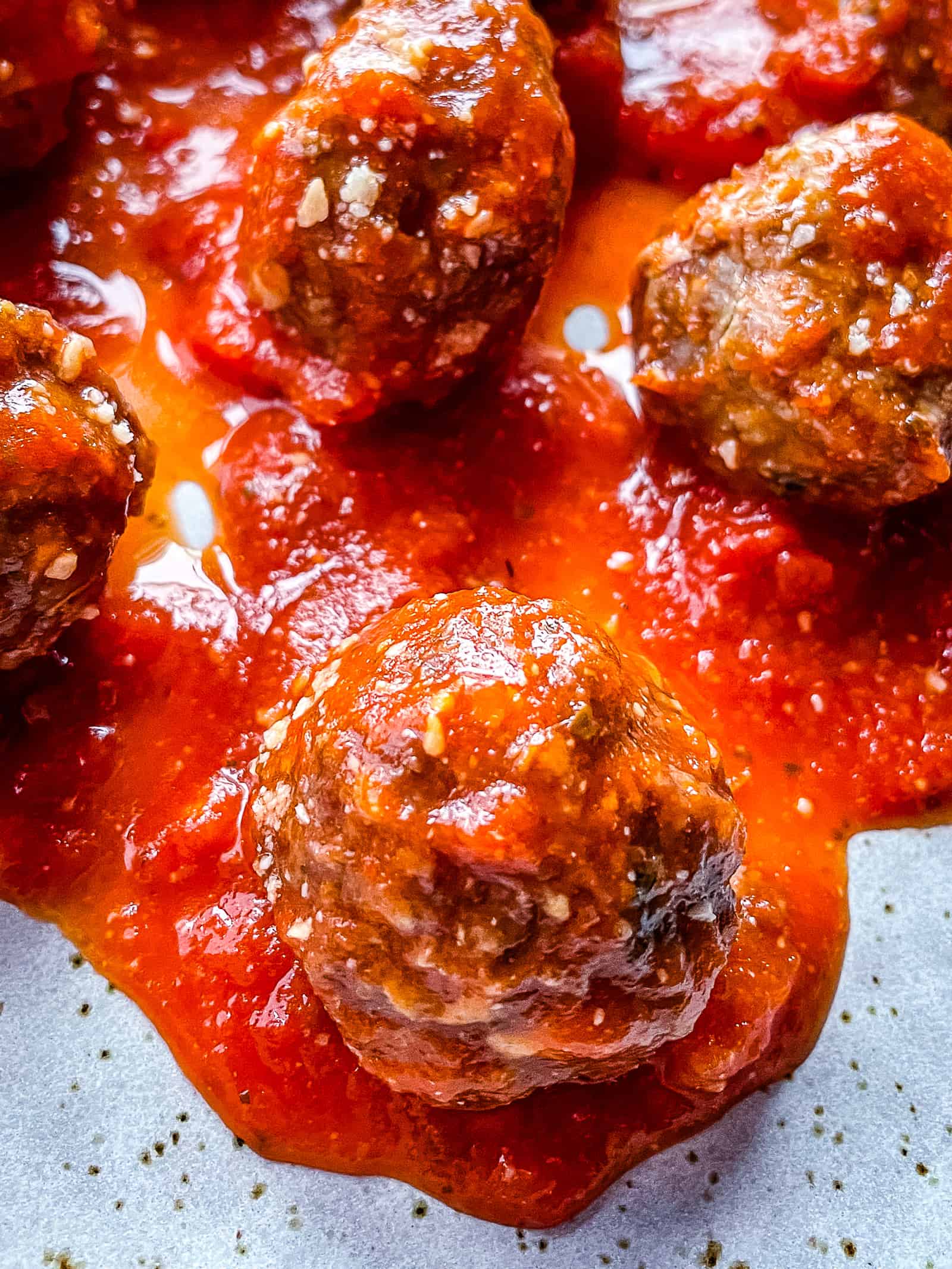 Closeup of baked meatballs in pasta sauce.