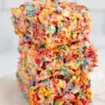 Three homemade fruity pebbles cereal bars in a stack.