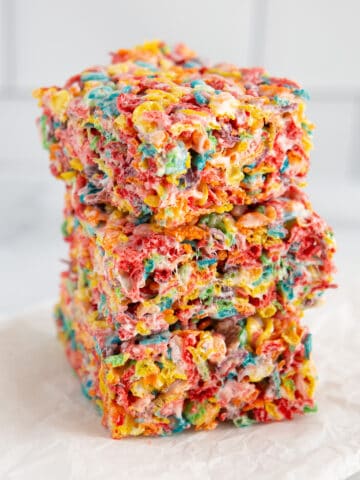 Three homemade fruity pebbles cereal bars in a stack.