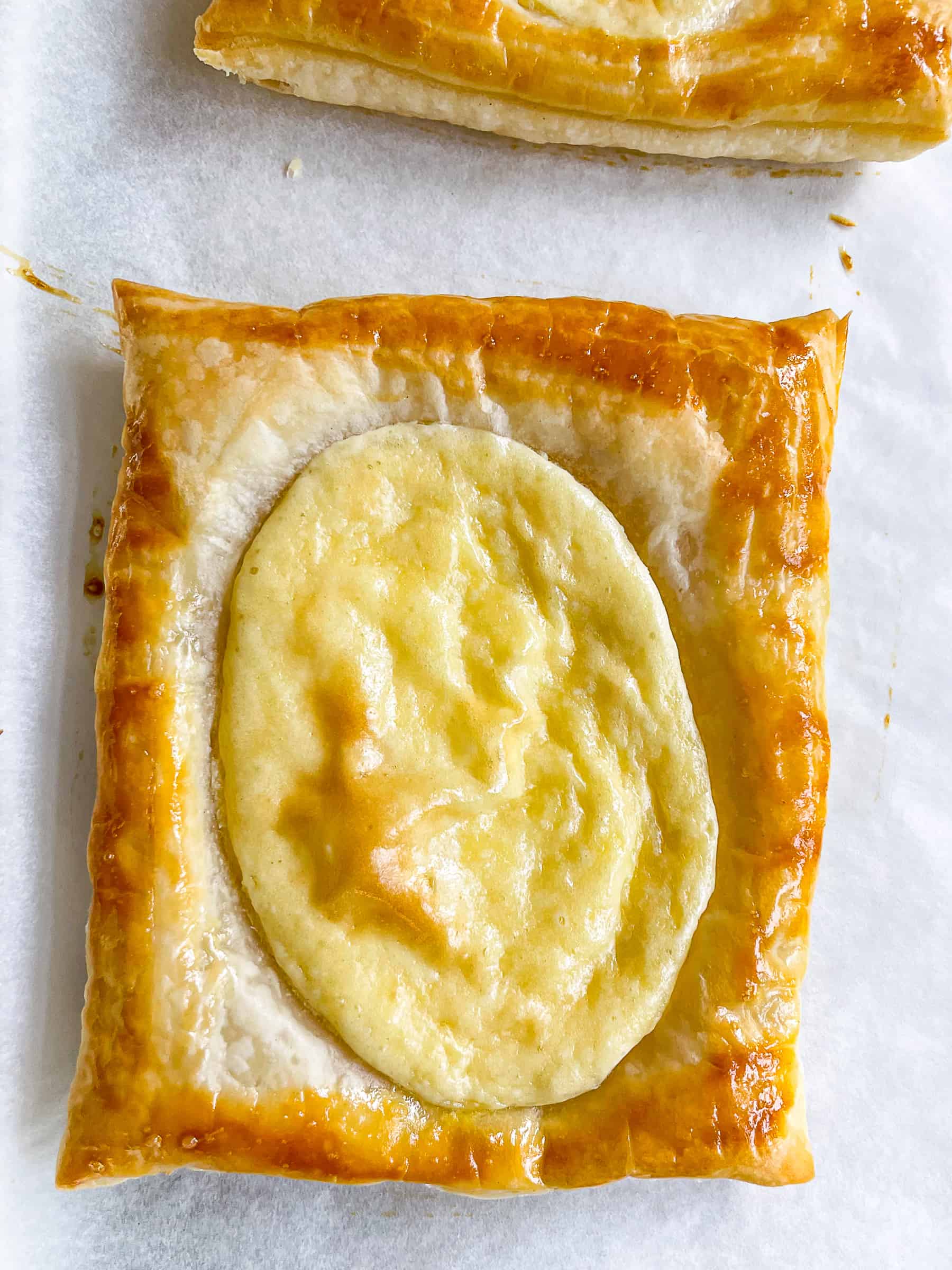 Puff pastry cream cheese danish cooling on a baking sheet.