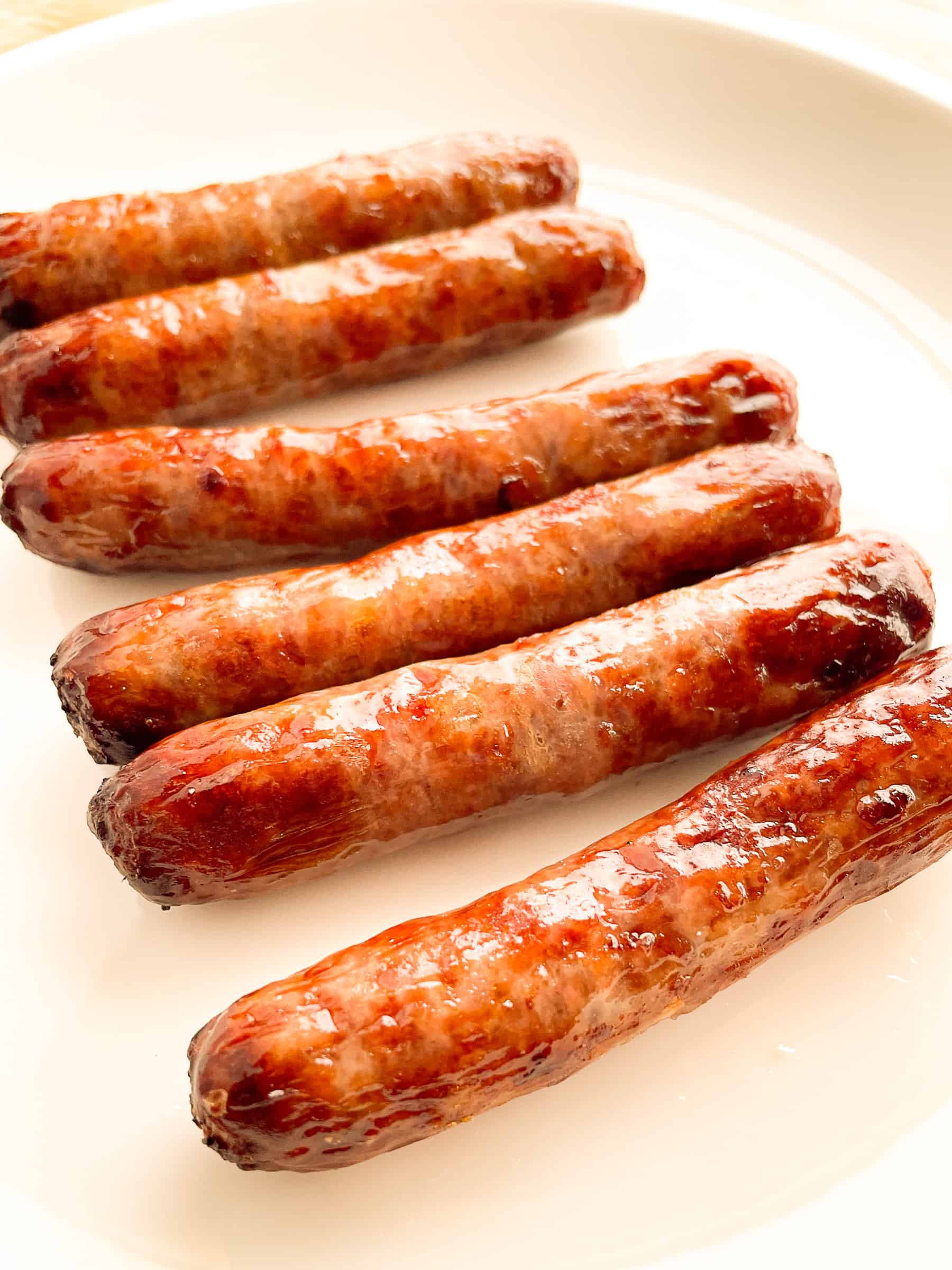 Air fried breakfast sausage links on a white plate.