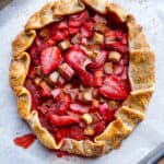Strawberry rhubarb galette cooling on a baking sheet.
