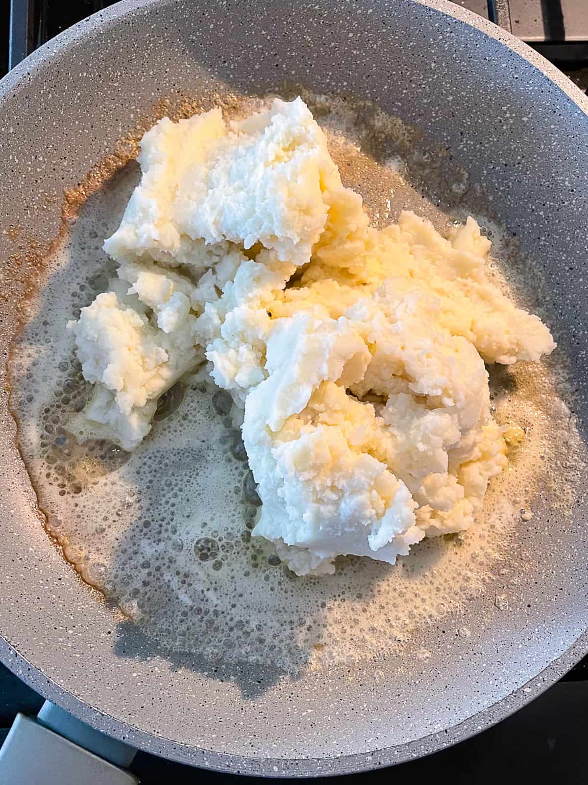Mashed potatoes and lightly brown butter in a skillet.