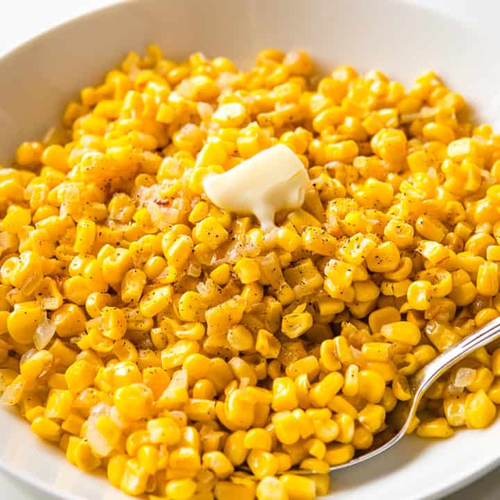 Frozen corn cooked with onion and topped with black pepper and butter.