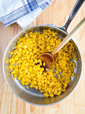 Cooked can corn with butter and salt in a small pan.